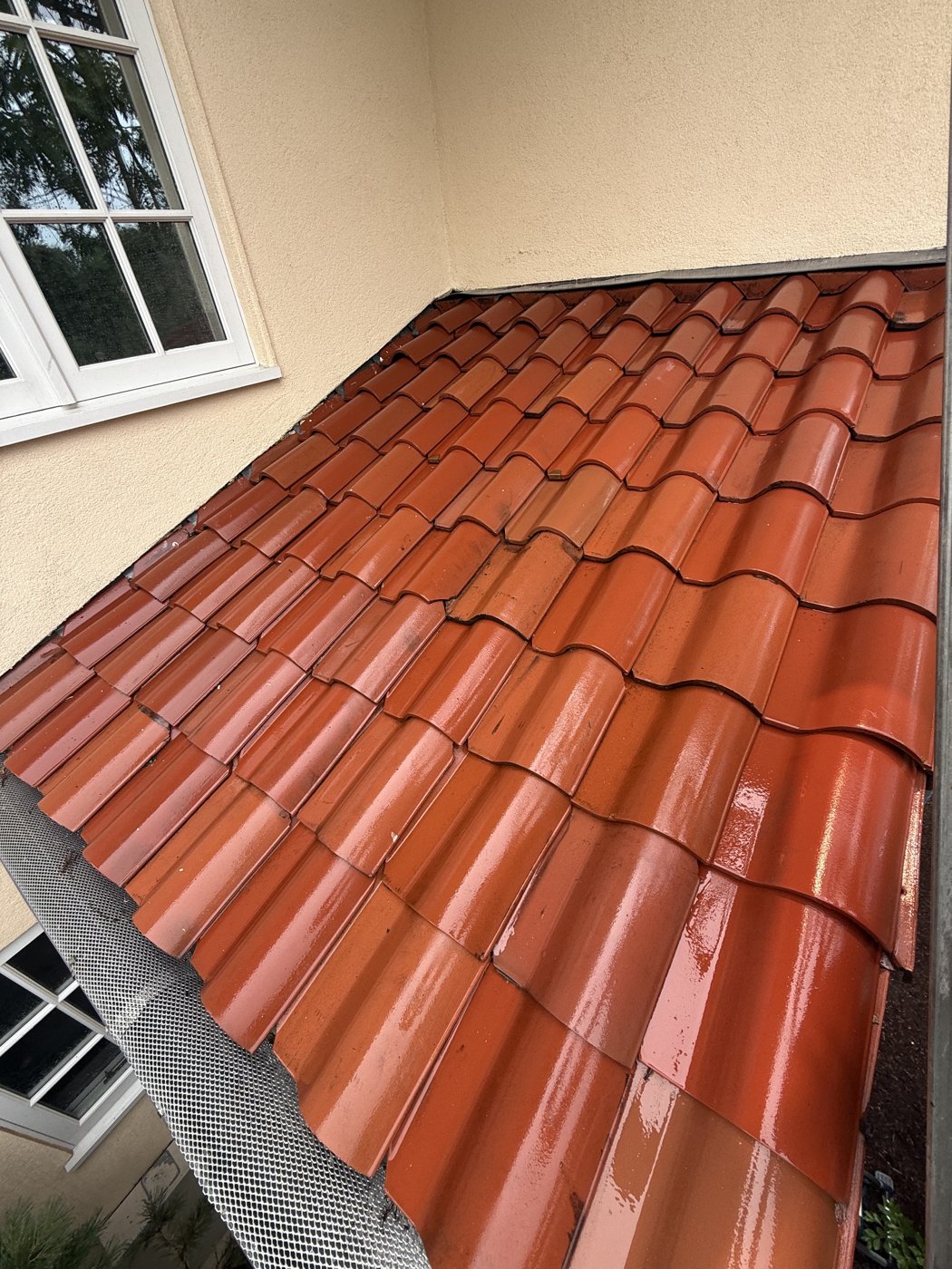 Red roof tiles beside a window